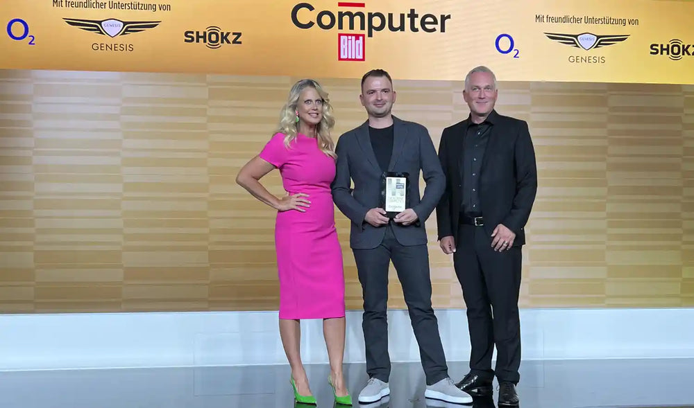 Preisübergabe bei der Leserwahl von Computer Bild 2023: drei Personen auf der Bühne, eine hält die Trophäe
